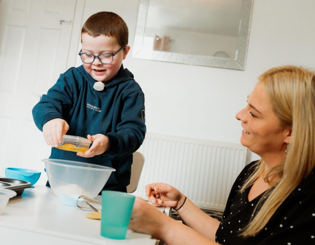 Riley, a child supported by Family Fund, baking with his mum