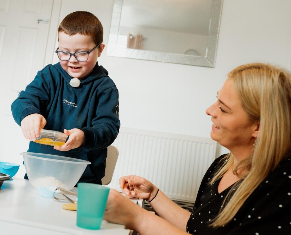 Riley, a child supported by Family Fund, baking with his mum